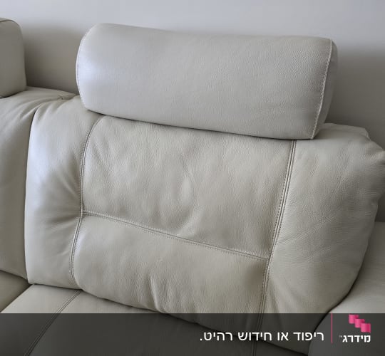 כרית עור לבנה על ספה עם ריפוד